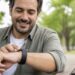 Personne consultant les notifications de sa montre connectée en extérieur