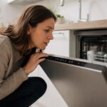 Voyant lave-vaisselle Beko explique Femme observant les voyants allumes sur le bandeau d'un lave-vaisselle