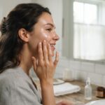 Femme applique un soin léger pour peau grasse Femme appliquant un soin gel léger sur une peau à tendance grasse devant un miroir de salle de bain